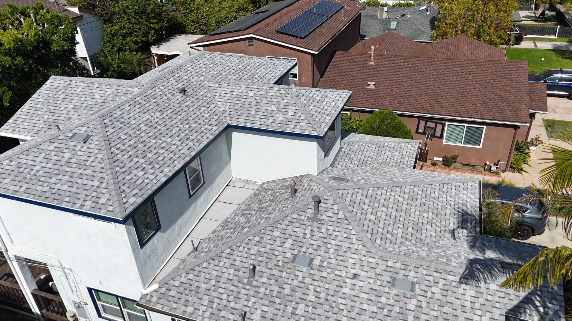 Aerial view of completed gray asphalt shingle hip roof with vents | Roof Replacement Inc Aerial view of completed gray asphalt shingle hip roof with vents — Roof Replacement Inc