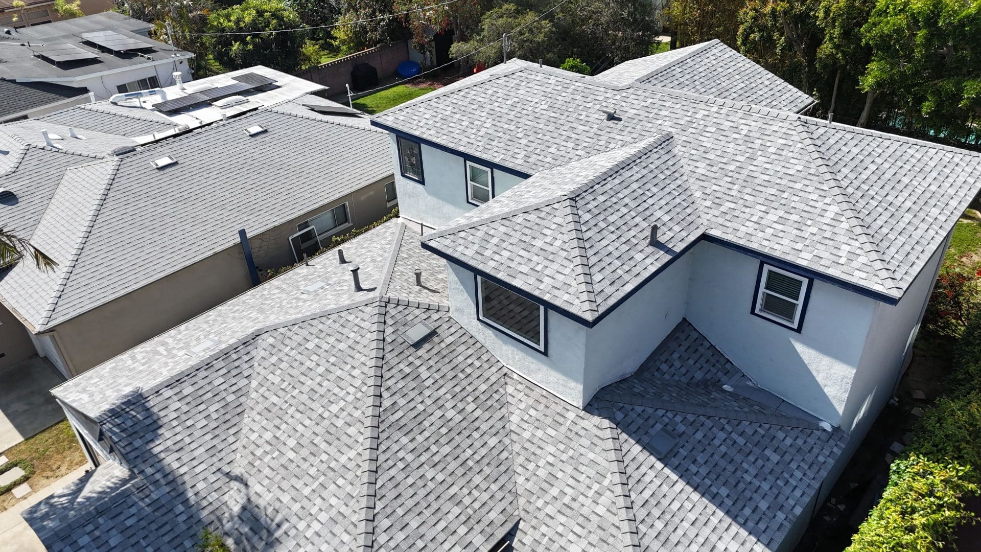Aerial view of completed gray asphalt shingle hip roof with multiple valleys | Roof Replacement Inc Aerial view of completed gray asphalt shingle hip roof with multiple valleys — Roof Replacement Inc
