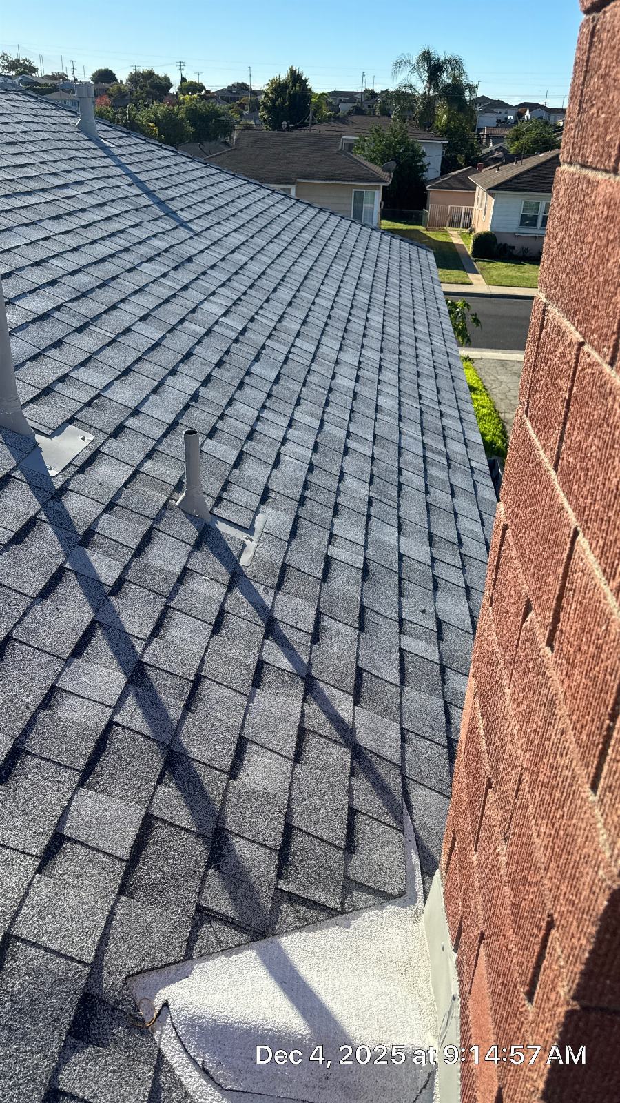 Gray asphalt shingle roof with pipe penetrations and brick chimney | Roof Replacement Inc Gray asphalt shingle roof with pipe penetrations and brick chimney — Roof Replacement Inc