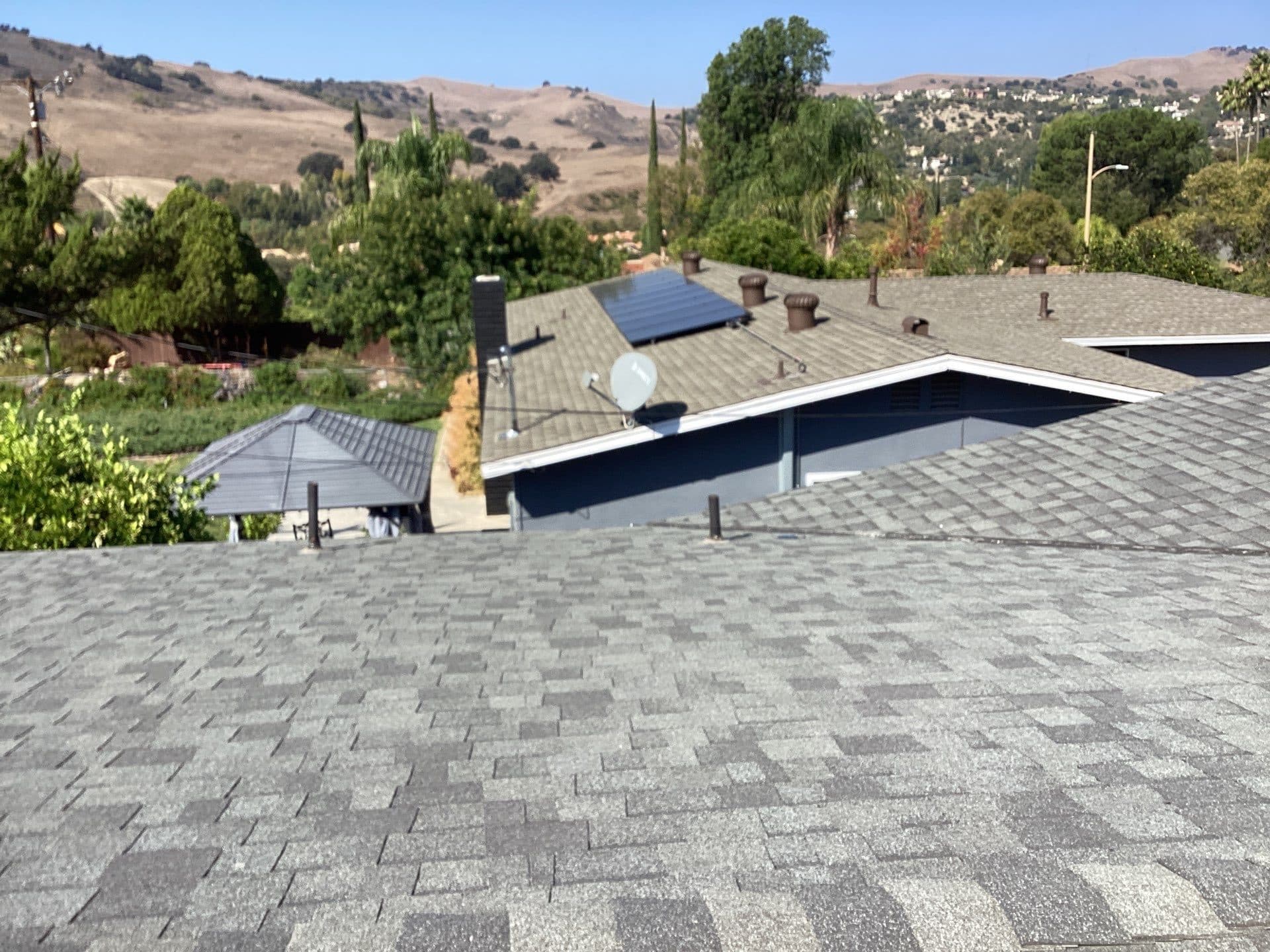 gray asphalt shingle roof with solar panels and satellite dish — Calabasas — Roof Replacement Inc
