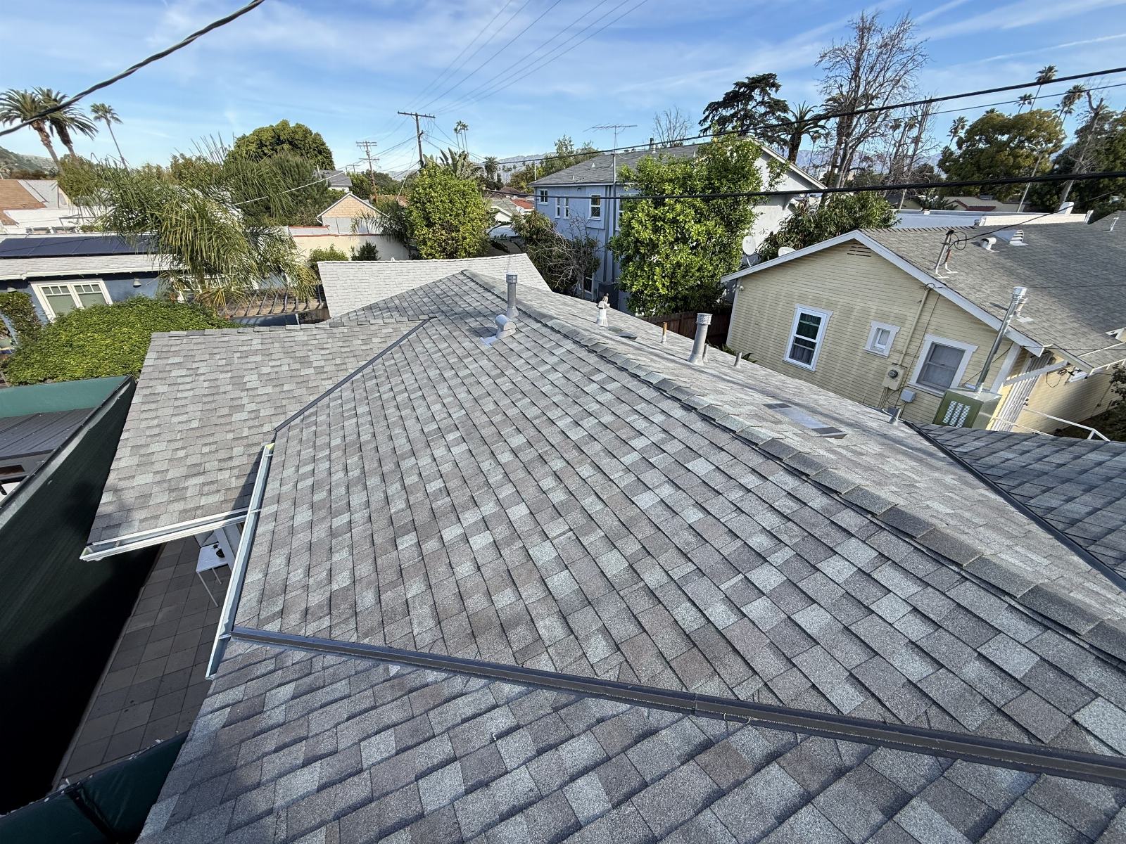 Gray asphalt shingle roof with pipe vents and metal rails | Roof Replacement Inc gray asphalt shingle roof with pipe vents and metal rails — Roof Replacement Inc