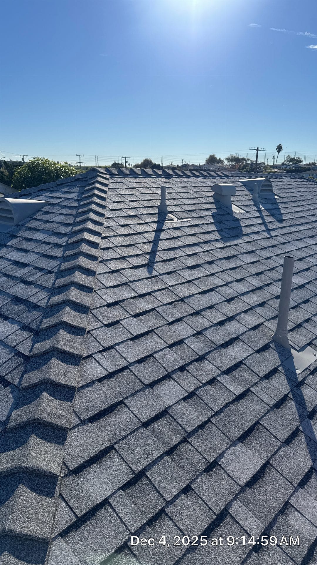 Newly installed gray asphalt shingle roof with ridge vents and pipe boots | Roof Replacement Inc Newly installed gray asphalt shingle roof with ridge vents and pipe boots — Roof Replacement Inc
