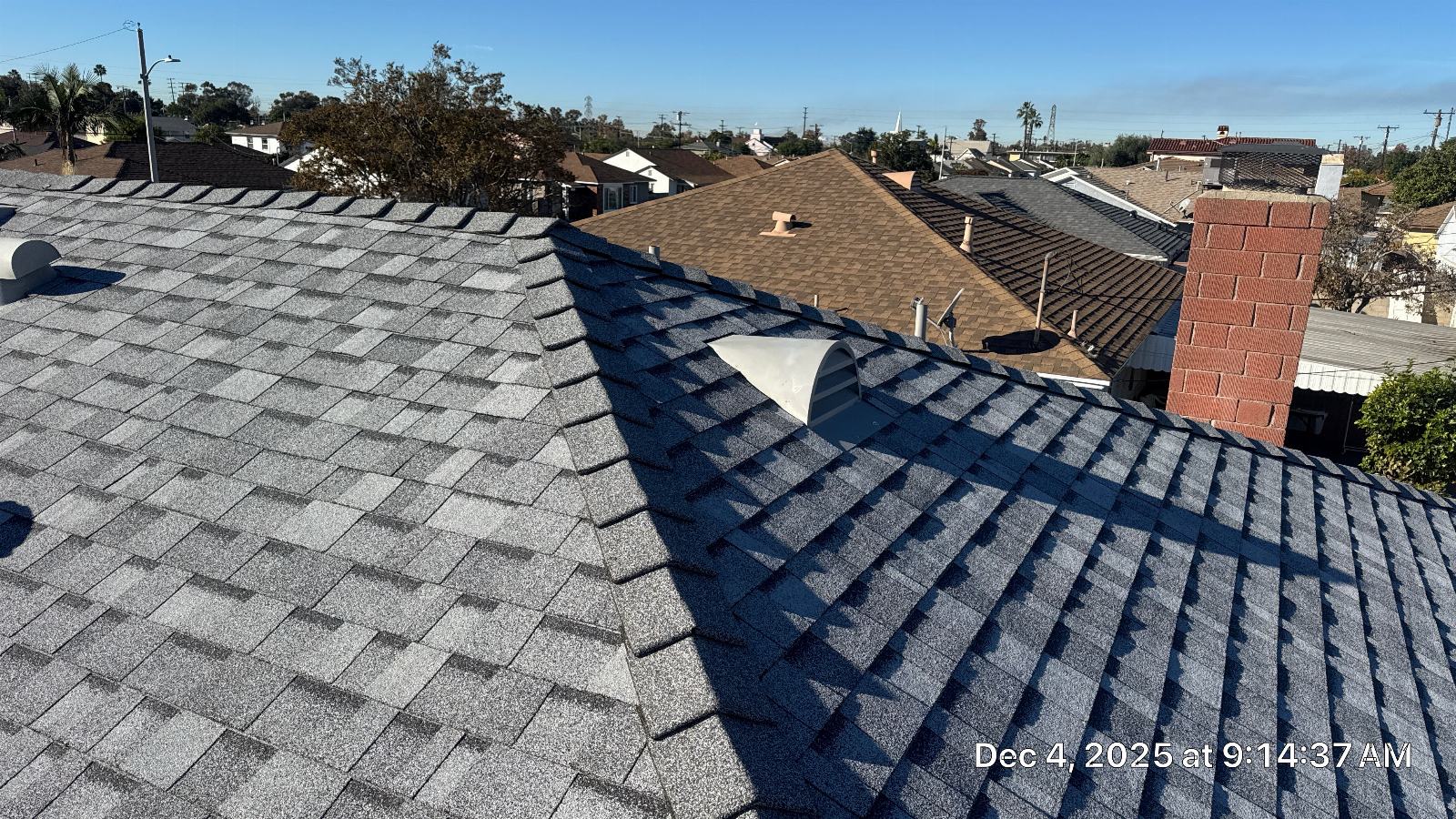 Gray asphalt shingle roof with brick chimney and plumbing vents | Roof Replacement Inc Gray asphalt shingle roof with brick chimney and plumbing vents — Roof Replacement Inc