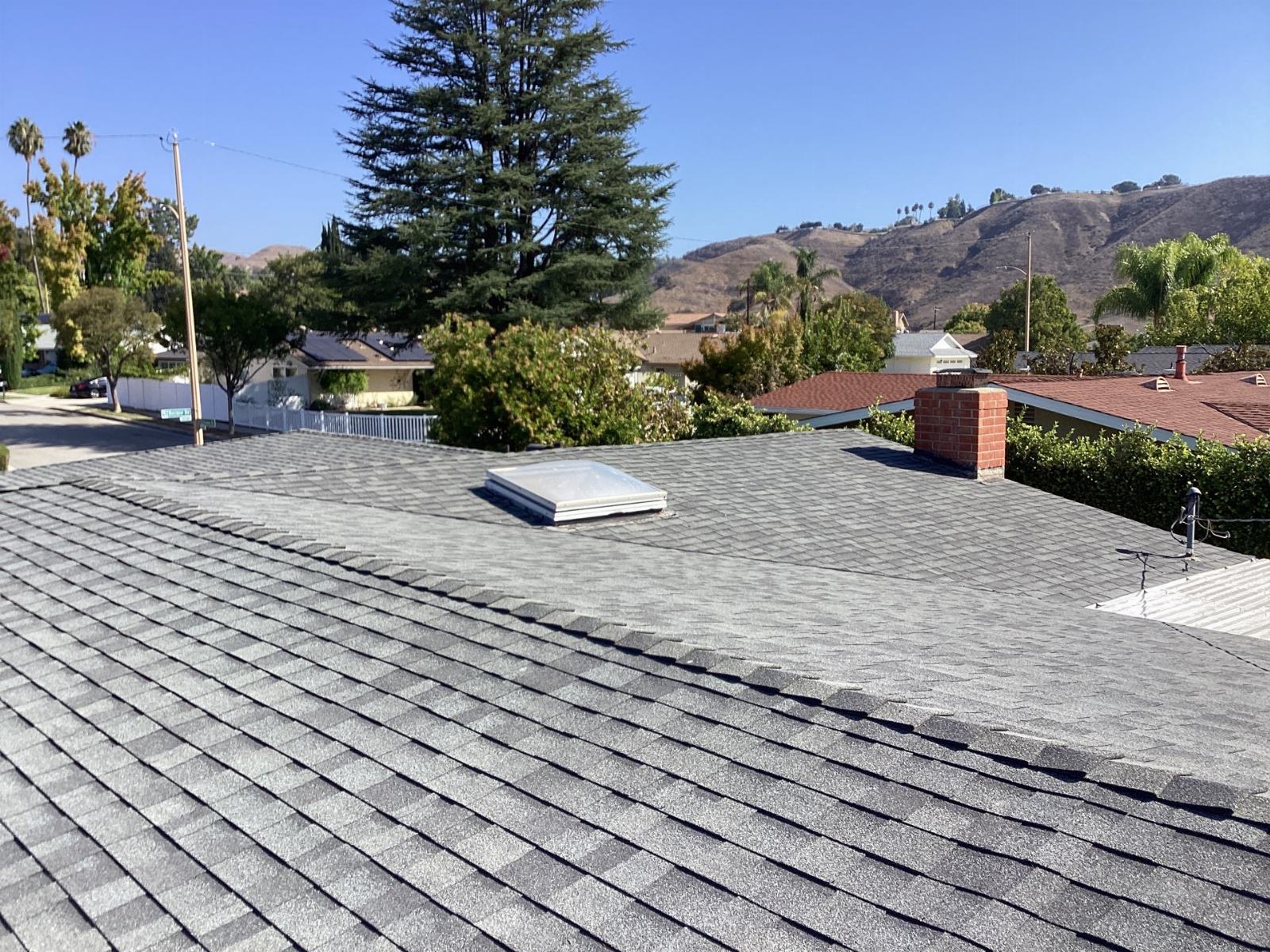gray asphalt shingle roof with skylight and brick chimney — Calabasas — Roof Replacement Inc