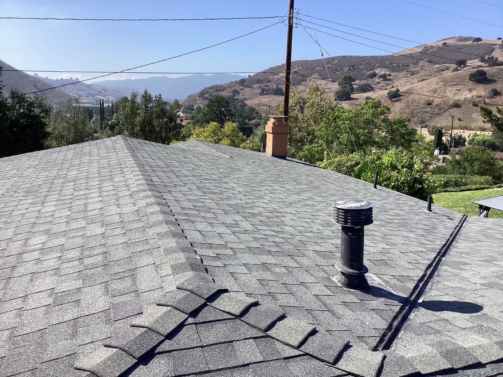 gray asphalt shingle roof with black plumbing vent and brick chimney — Calabasas — Roof Replacement Inc