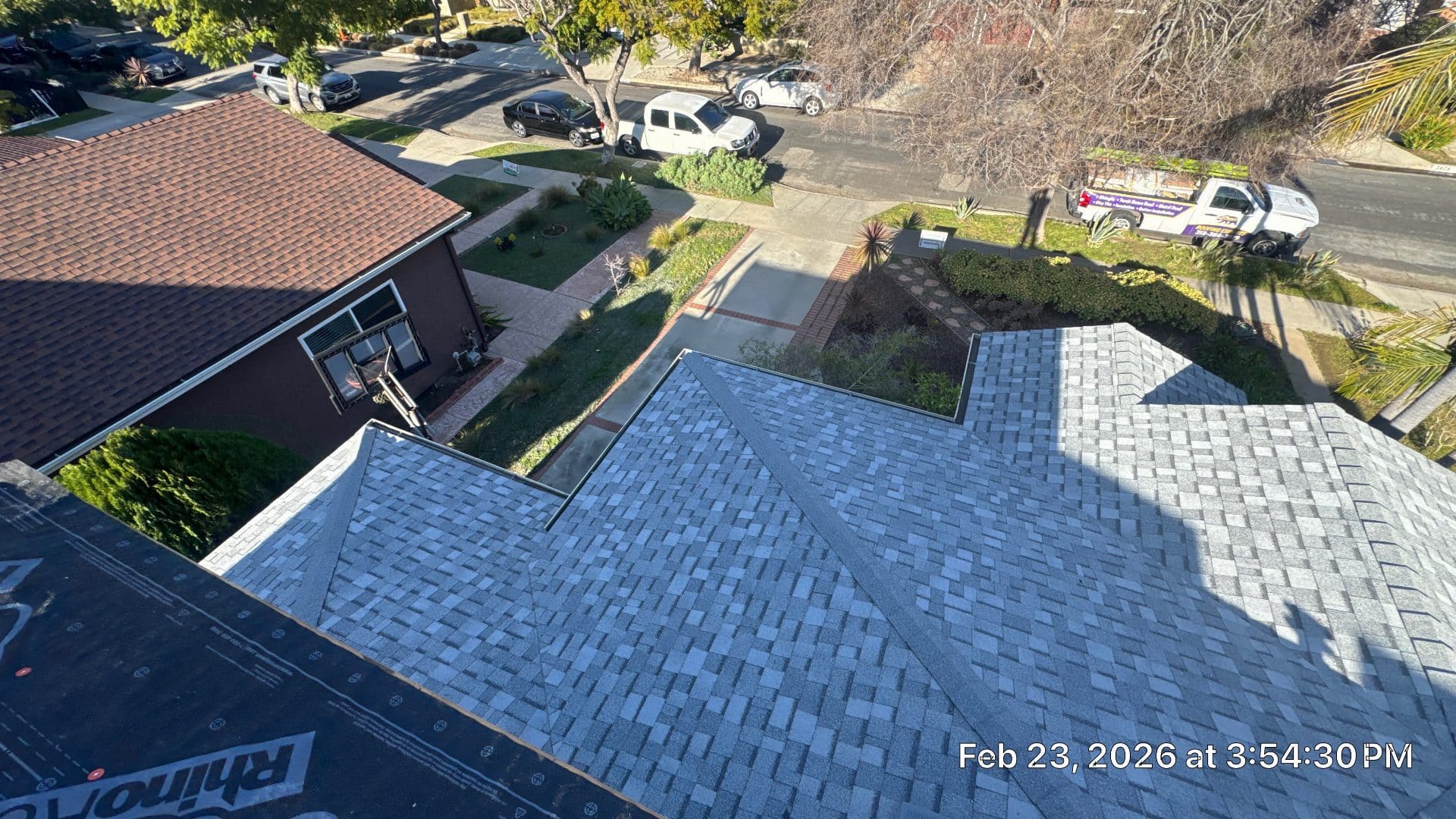 Newly installed grey asphalt shingles on hip roof, RhinoRoof underlayment visible | Roof Replacement Inc Newly installed grey asphalt shingles on hip roof, RhinoRoof underlayment visible — Roof Replacement Inc
