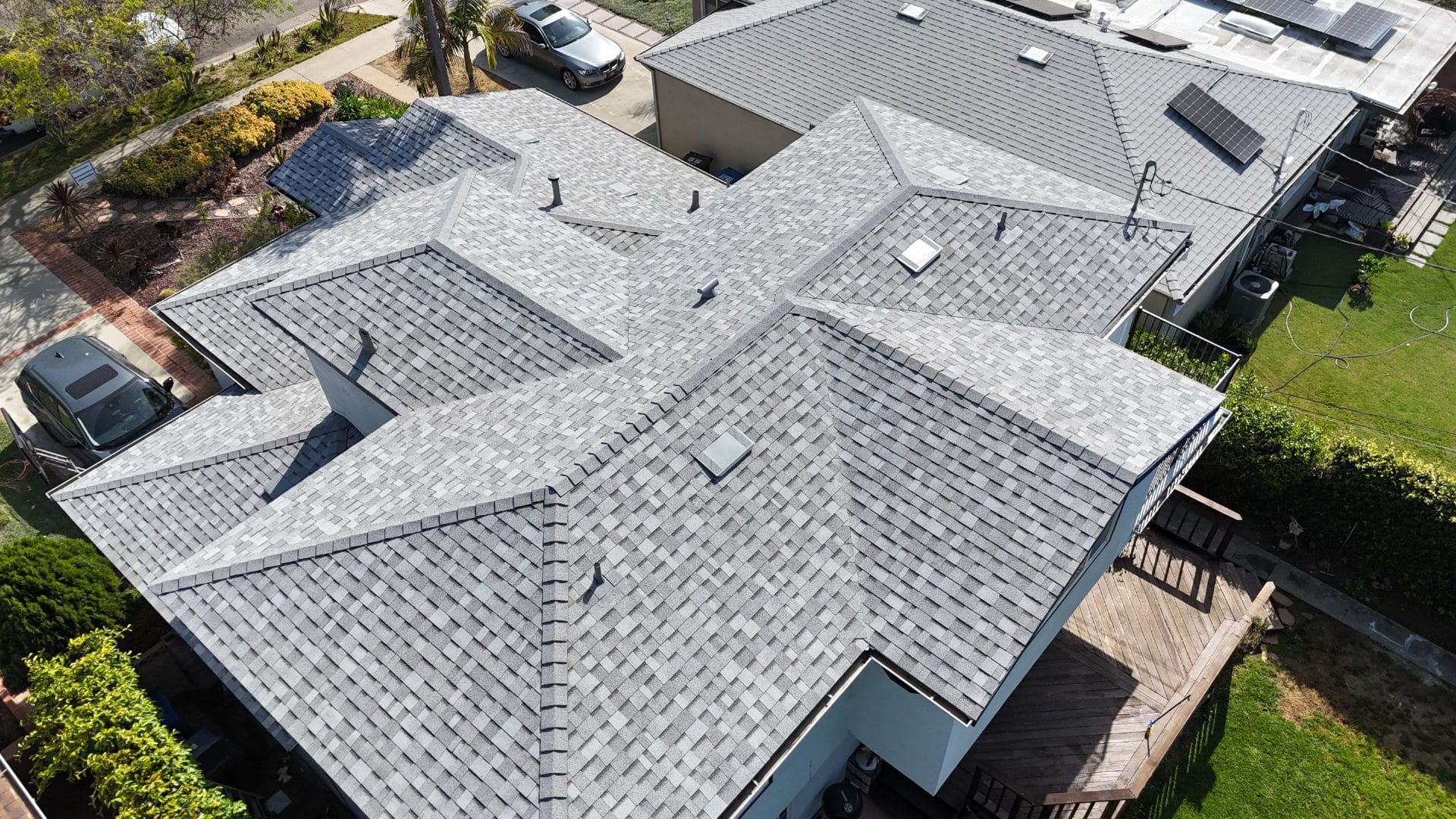 Aerial view of completed grey asphalt shingle roof with complex hip and valley layout | Roof Replacement Inc Aerial view of completed grey asphalt shingle roof with complex hip and valley layout — Roof Replacement Inc