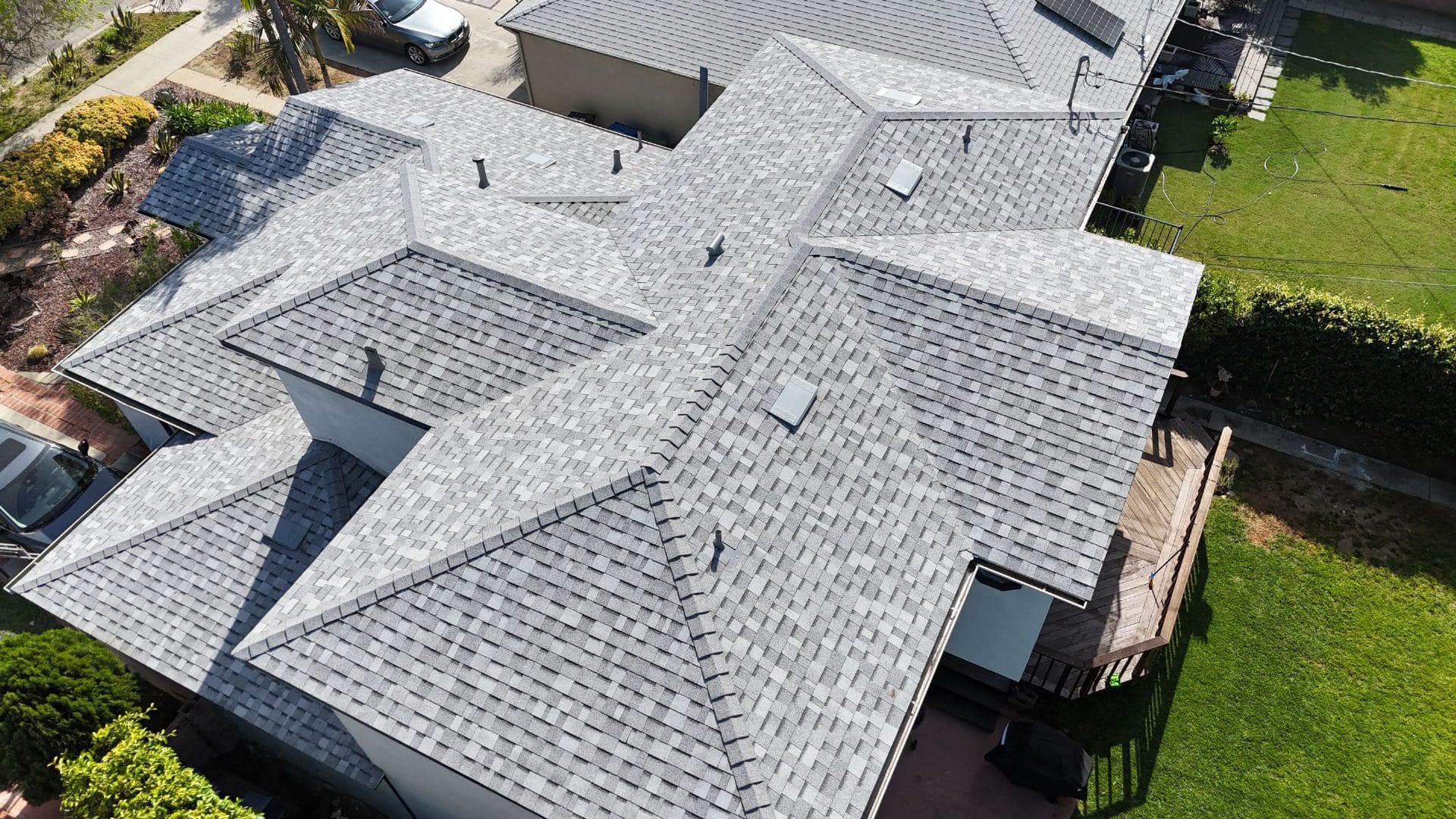 Aerial view of completed grey asphalt shingle hip roof with vents | Roof Replacement Inc Aerial view of completed grey asphalt shingle hip roof with vents — Roof Replacement Inc