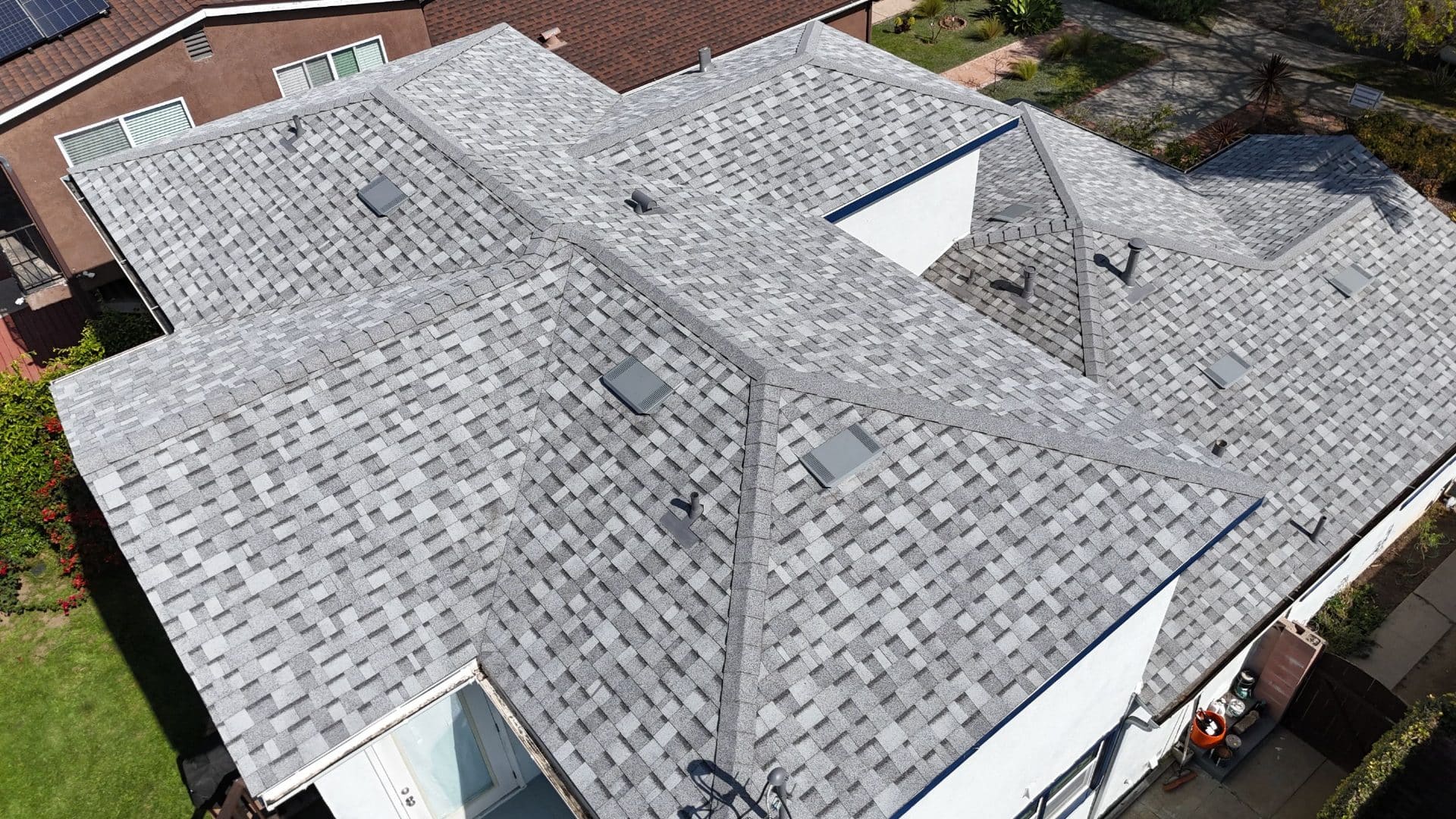 Aerial view of grey asphalt shingle hip roof with multiple ridges and vents | Roof Replacement Inc Aerial view of grey asphalt shingle hip roof with multiple ridges and vents — Roof Replacement Inc