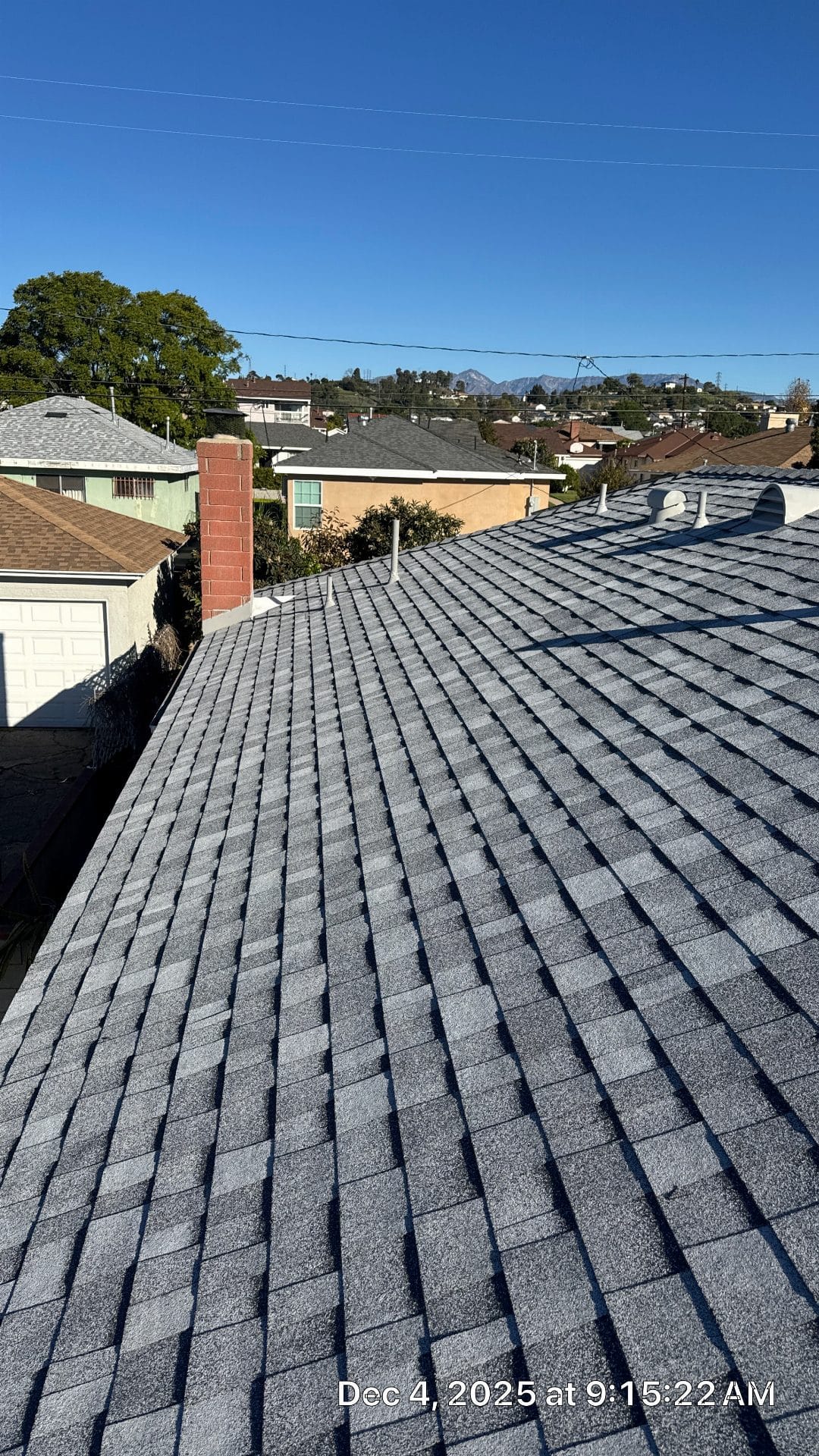 New grey asphalt shingle roof with brick chimney and pipe vents | Roof Replacement Inc New grey asphalt shingle roof with brick chimney and pipe vents — Roof Replacement Inc