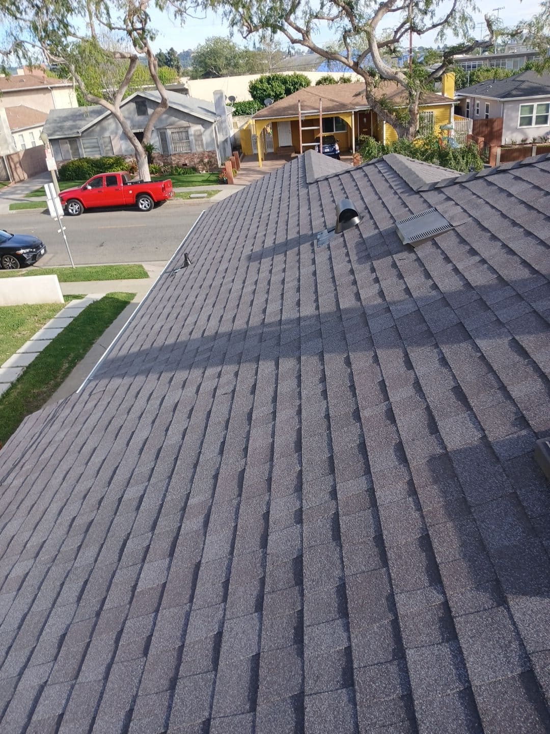 Newly installed grey asphalt shingle roof with pipe boot and roof vent | Roof Replacement Inc Newly installed grey asphalt shingle roof with pipe boot and roof vent — Roof Replacement Inc