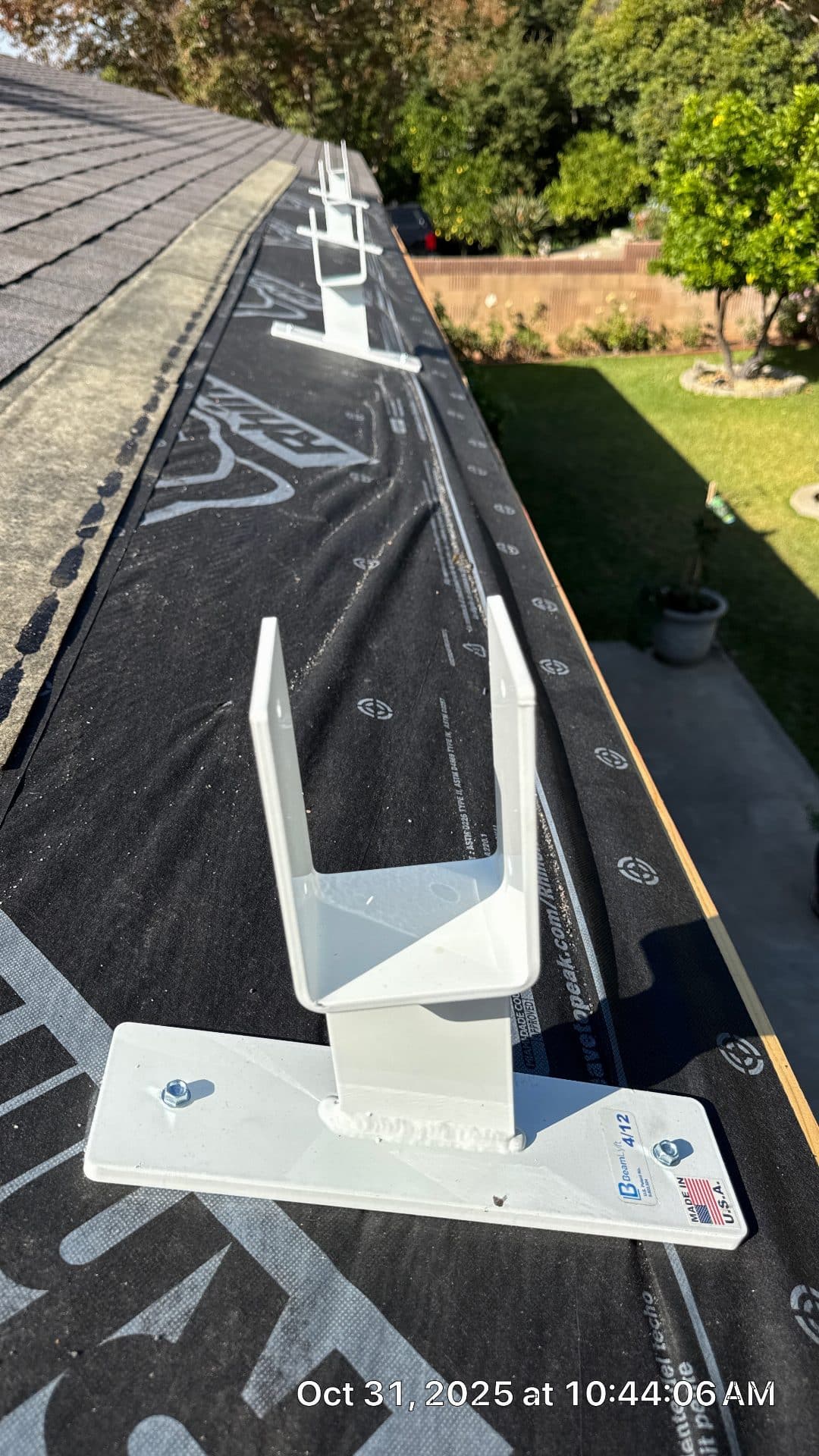 White gutter hanger brackets installed on black underlayment at eave | Roof Replacement Inc White gutter hanger brackets installed on black underlayment at eave — Roof Replacement Inc