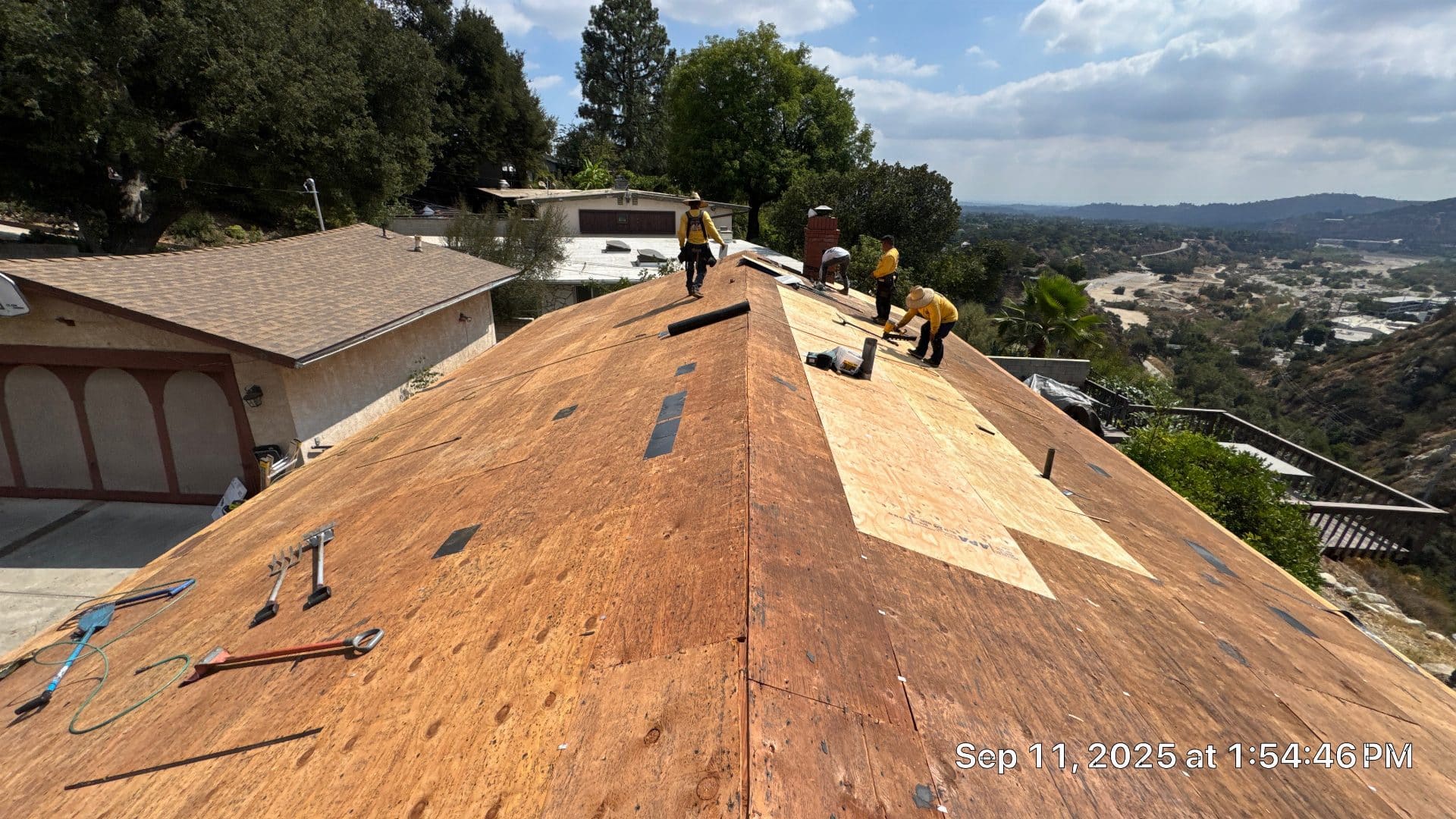 Roofers installing OSB sheathing on stripped hip roof deck in Altadena | Roof Replacement Inc roofers installing OSB sheathing on stripped hip roof deck — Altadena — Roof Replacement Inc
