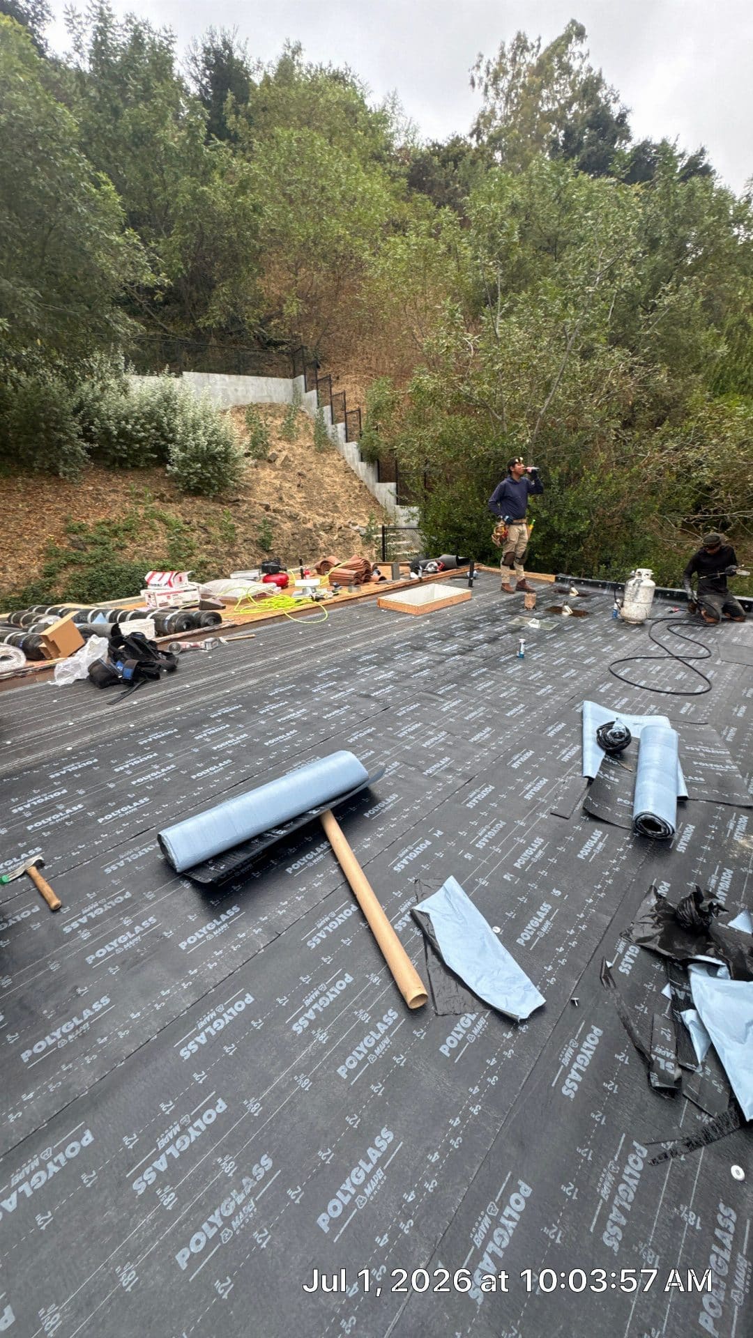 Workers installing Polyglass underlayment rolls on flat roof in North Hollywood | Roof Replacement Inc workers installing Polyglass underlayment rolls on flat roof — North Hollywood — Roof Replacement Inc