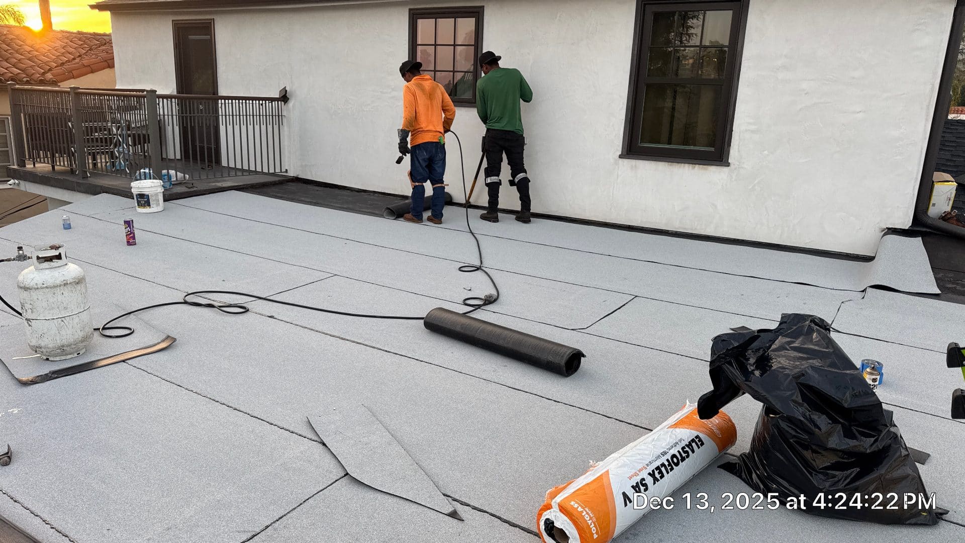 Two roofers torch-applying Elastoflex SA V modified bitumen membrane flat roof in Glendale | Roof Replacement Inc two roofers torch-applying Elastoflex SA V modified bitumen membrane flat roof — Glendale — Roof Replacement Inc