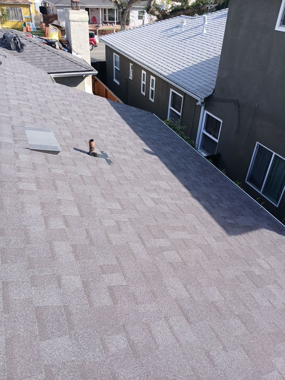 New gray asphalt shingle roof with pipe boot flashing and roof vent — Roof Replacement Inc