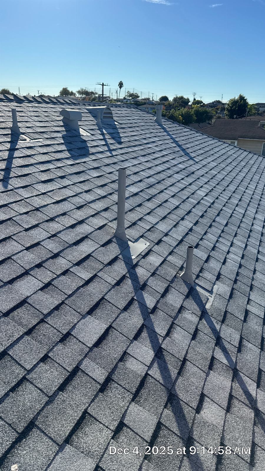New gray asphalt shingle roof with white plumbing vent pipes and mounts — Roof Replacement Inc
