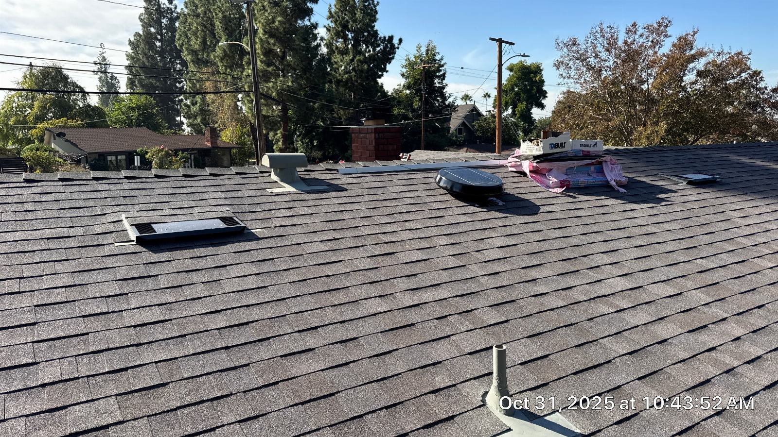 New gray asphalt shingle roof with vents, skylight, and chimney — Roof Replacement Inc