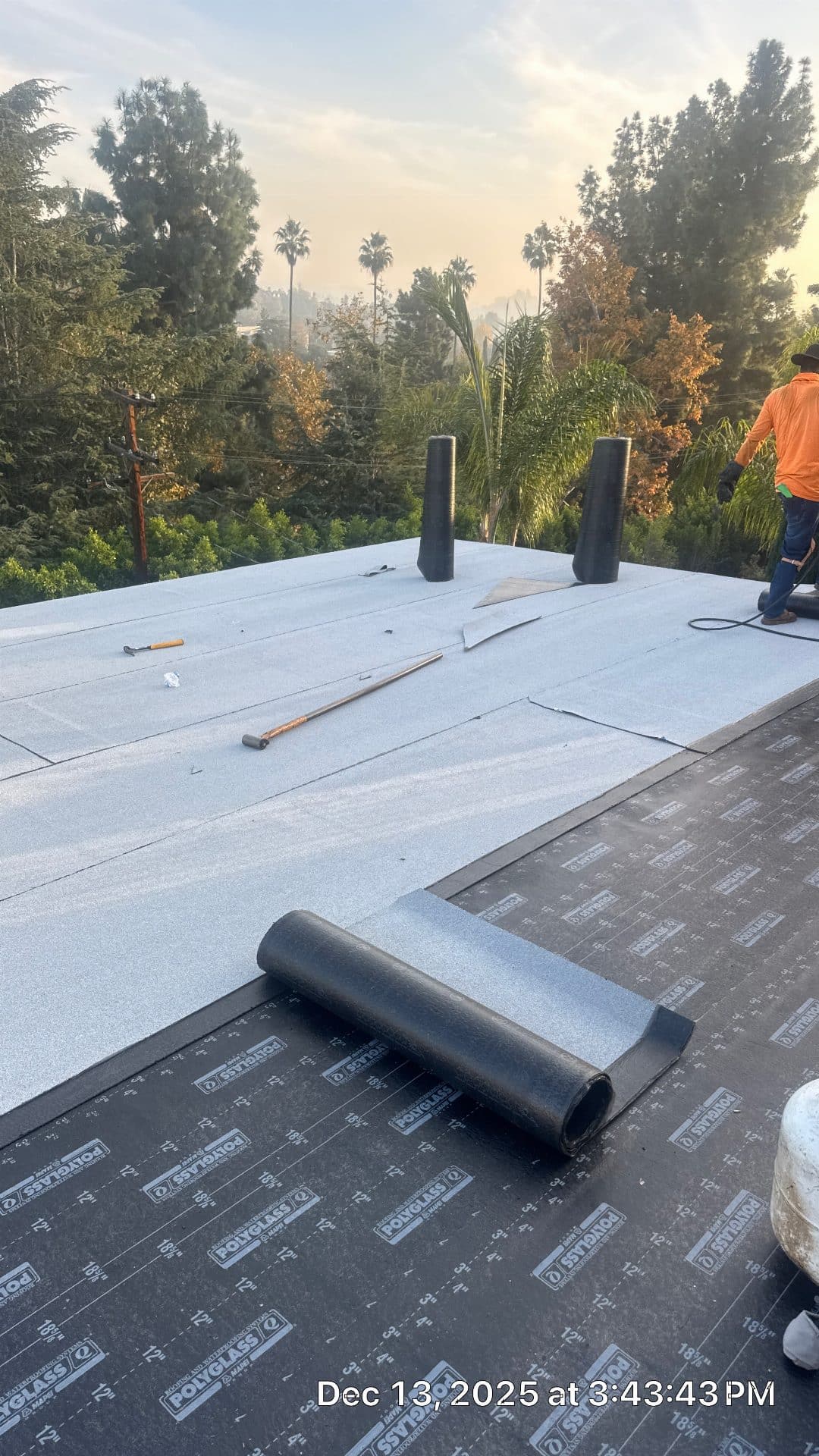 Polyglass modified bitumen cap sheet being installed on flat roof in Glendale | Roof Replacement Inc Polyglass modified bitumen cap sheet being installed on flat roof — Glendale — Roof Replacement Inc