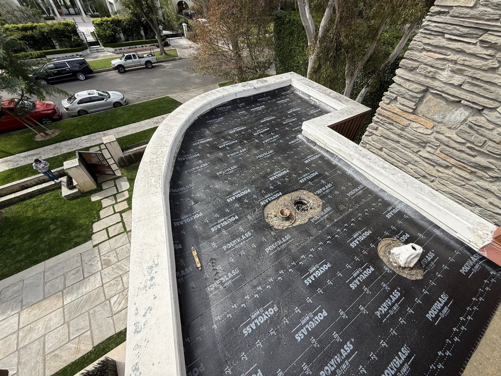 Polyglass underlayment installed on curved flat roof with drain penetrations in Beverly Hills | Roof Replacement Inc Polyglass underlayment installed on curved flat roof with drain penetrations — Beverly Hills — Roof Replacement Inc