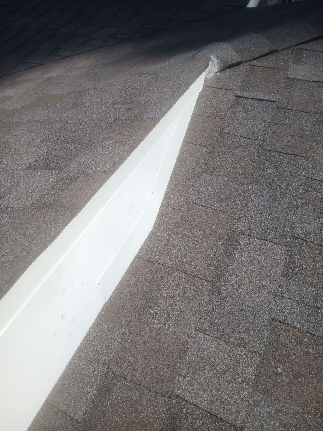 White PVC ridge cap over brown asphalt shingles, hip line | Roof Replacement Inc White PVC ridge cap over brown asphalt shingles, hip line — Roof Replacement Inc
