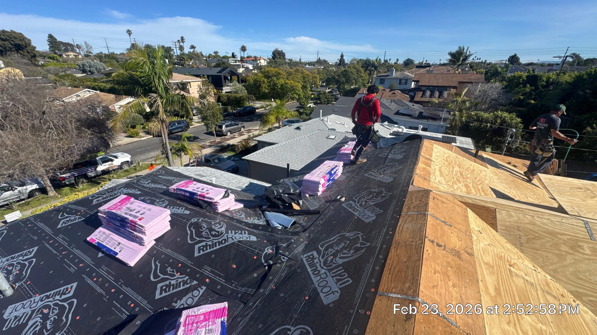 Crew installing RhinoRoof underlayment and shingle bundles on plywood deck | Roof Replacement Inc Crew installing RhinoRoof underlayment and shingle bundles on plywood deck — Roof Replacement Inc