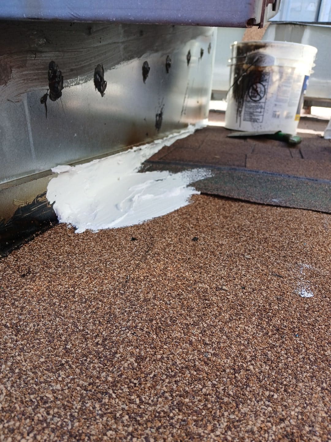 White sealant applied at metal curb base on gravel built-up roof | Roof Replacement Inc White sealant applied at metal curb base on gravel built-up roof — Roof Replacement Inc