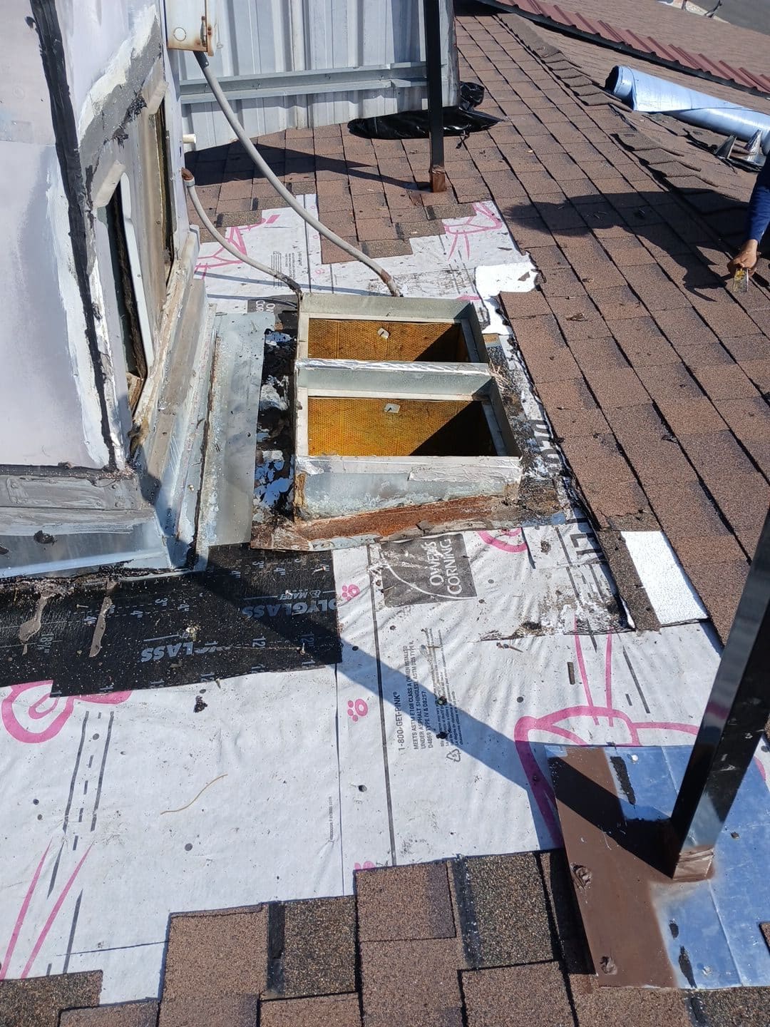 Roof penetration opening with corroded curb, underlayment, and asphalt shingles mid-installation. | Roof Replacement Inc Roof penetration opening with corroded curb, underlayment, and asphalt shingles mid-installation. — Roof Replacement Inc