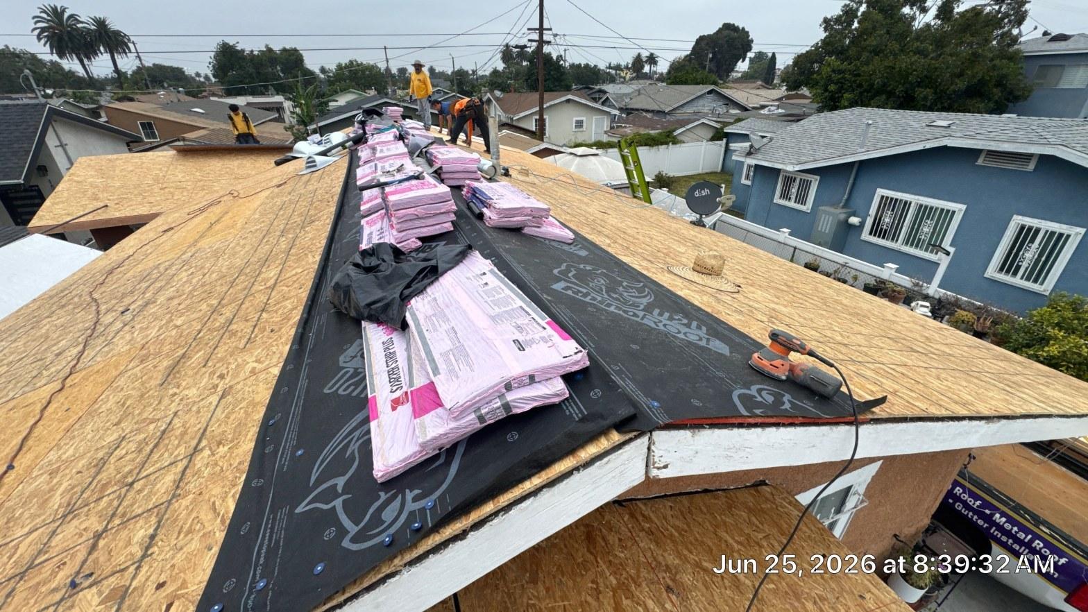 Roof tear-off showing old shingles stripped to bare deck during a full roof removal in Southern California