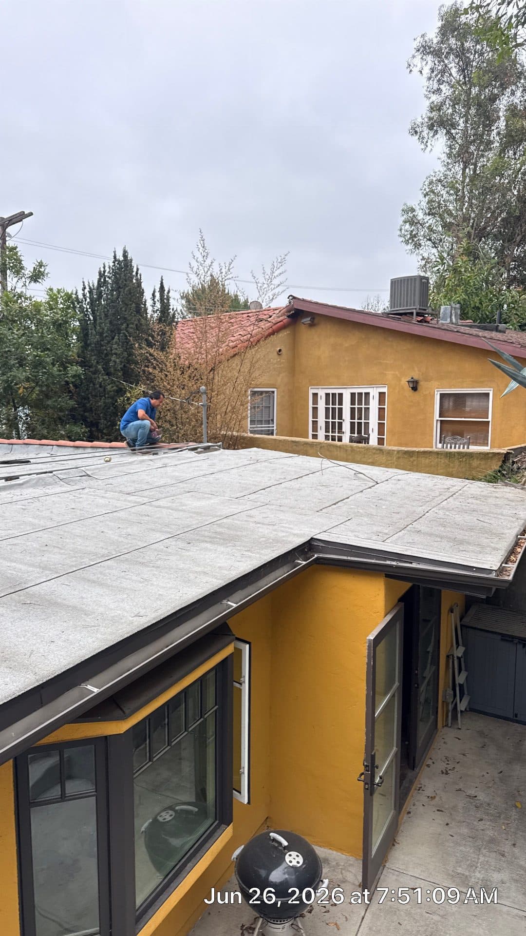 roofer working on flat roof with rolled membrane material — North Hollywood — Roof Replacement Inc