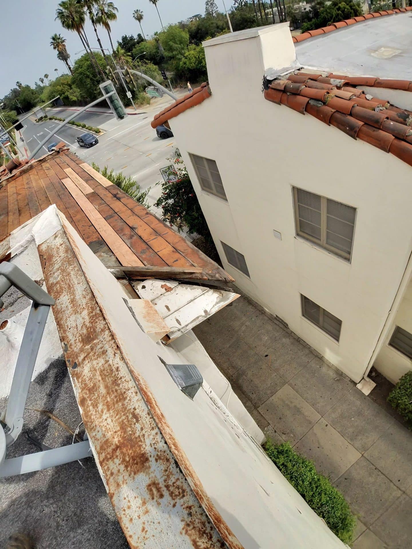 Deteriorated roof edge with rusted metal flashing and exposed wood decking | Roof Replacement Inc Deteriorated roof edge with rusted metal flashing and exposed wood decking — Roof Replacement Inc