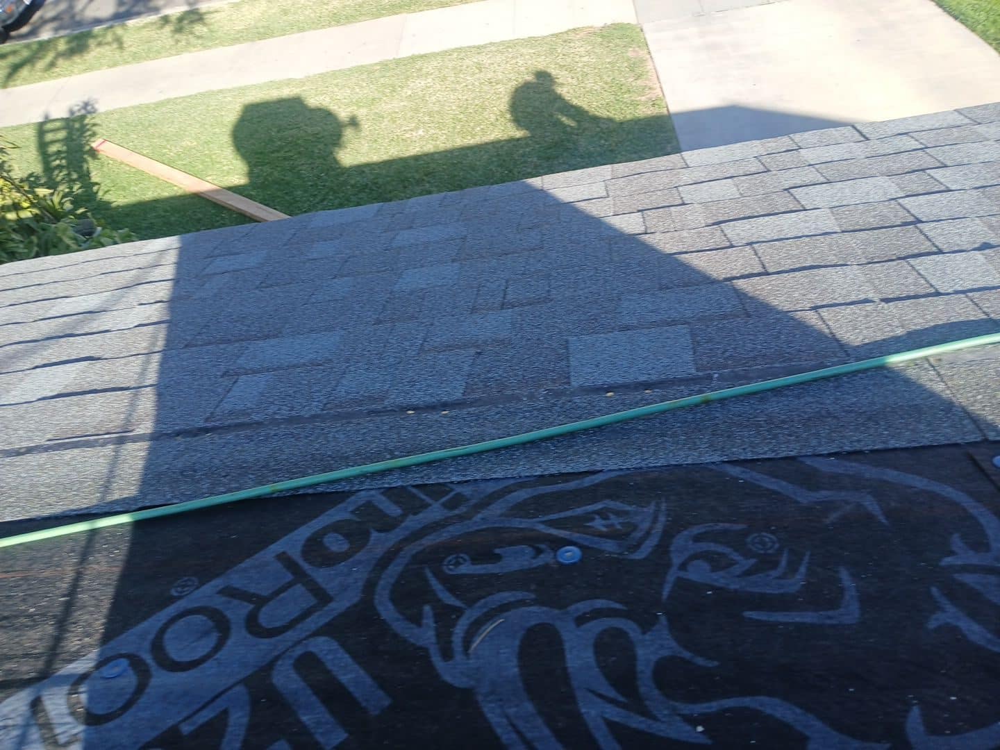 Asphalt shingles partially installed over black roofing underlayment with chalk line | Roof Replacement Inc asphalt shingles partially installed over black roofing underlayment with chalk line — Roof Replacement Inc