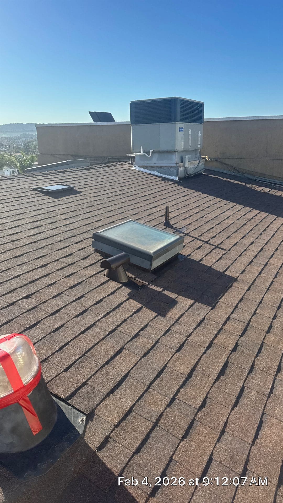 Asphalt shingle roof with skylight, pipe vents, rooftop HVAC unit — Roof Replacement Inc