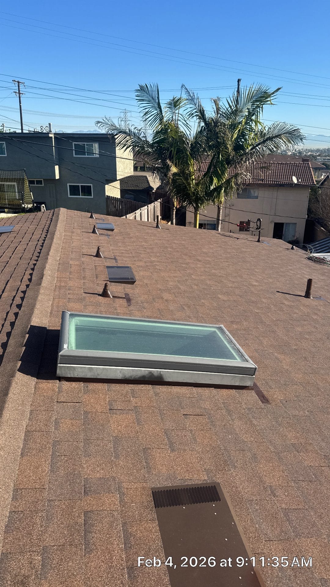 Asphalt shingle roof with flat glass skylight, vents, pipe boots — Roof Replacement Inc