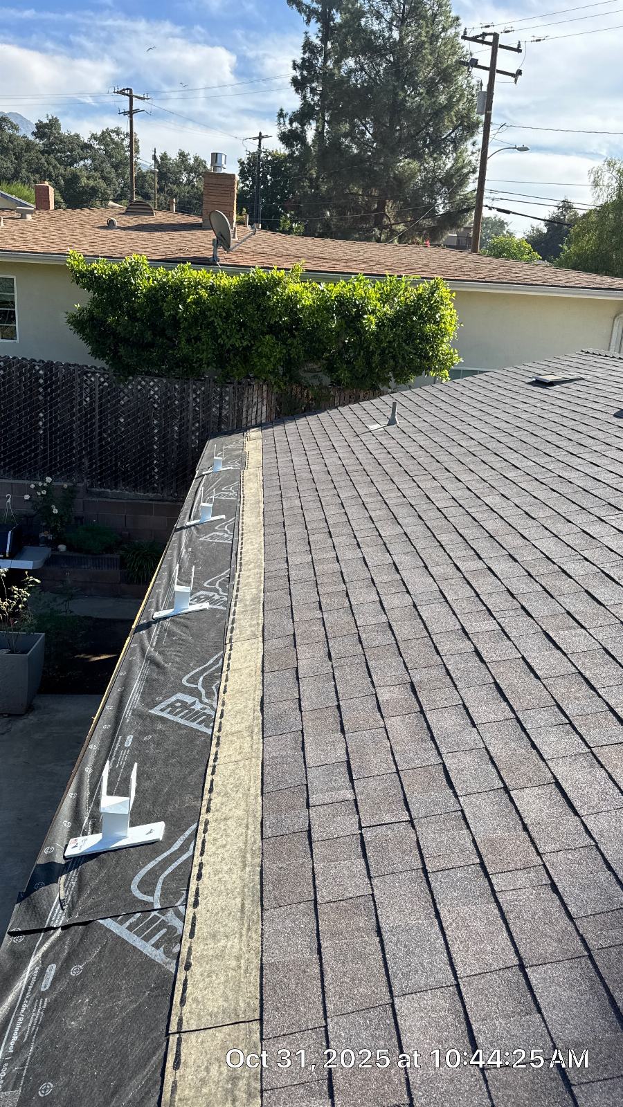 Asphalt shingle roof with solar mounting brackets and underlayment along eave edge | Roof Replacement Inc Asphalt shingle roof with solar mounting brackets and underlayment along eave edge — Roof Replacement Inc