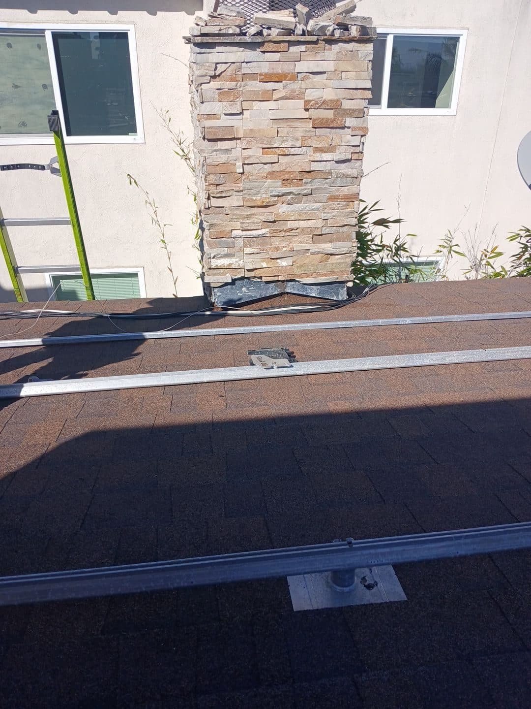 Asphalt shingle roof with solar rails, stone chimney, wiring runs | Roof Replacement Inc Asphalt shingle roof with solar rails, stone chimney, wiring runs — Roof Replacement Inc