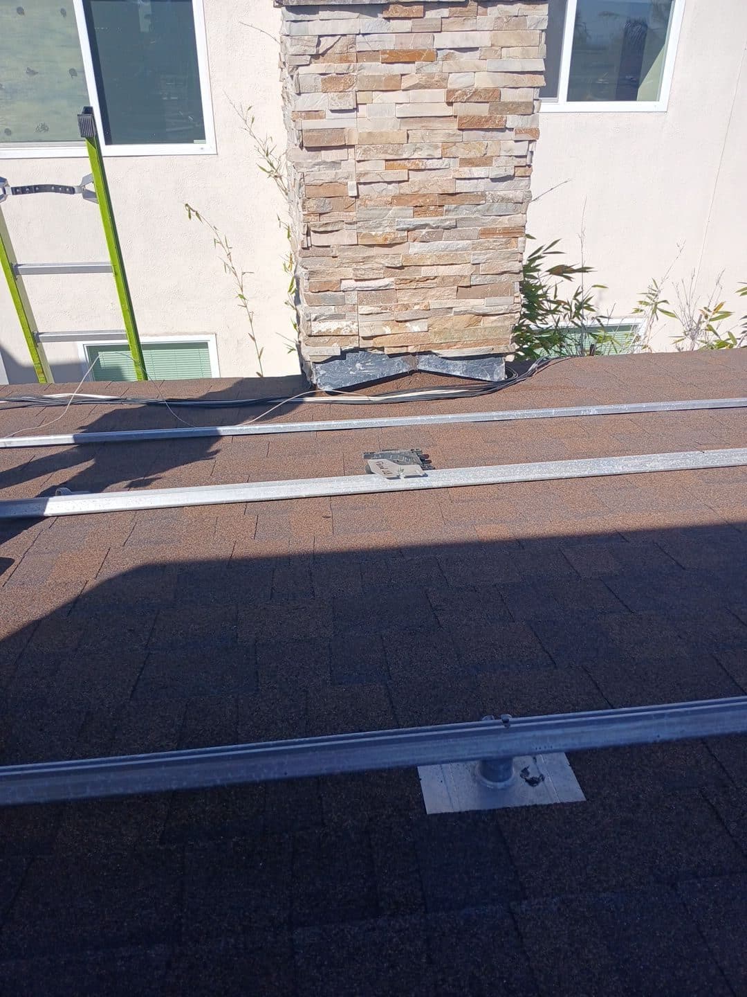 Asphalt shingle roof with solar racking rails, mount flashings, chimney — Roof Replacement Inc