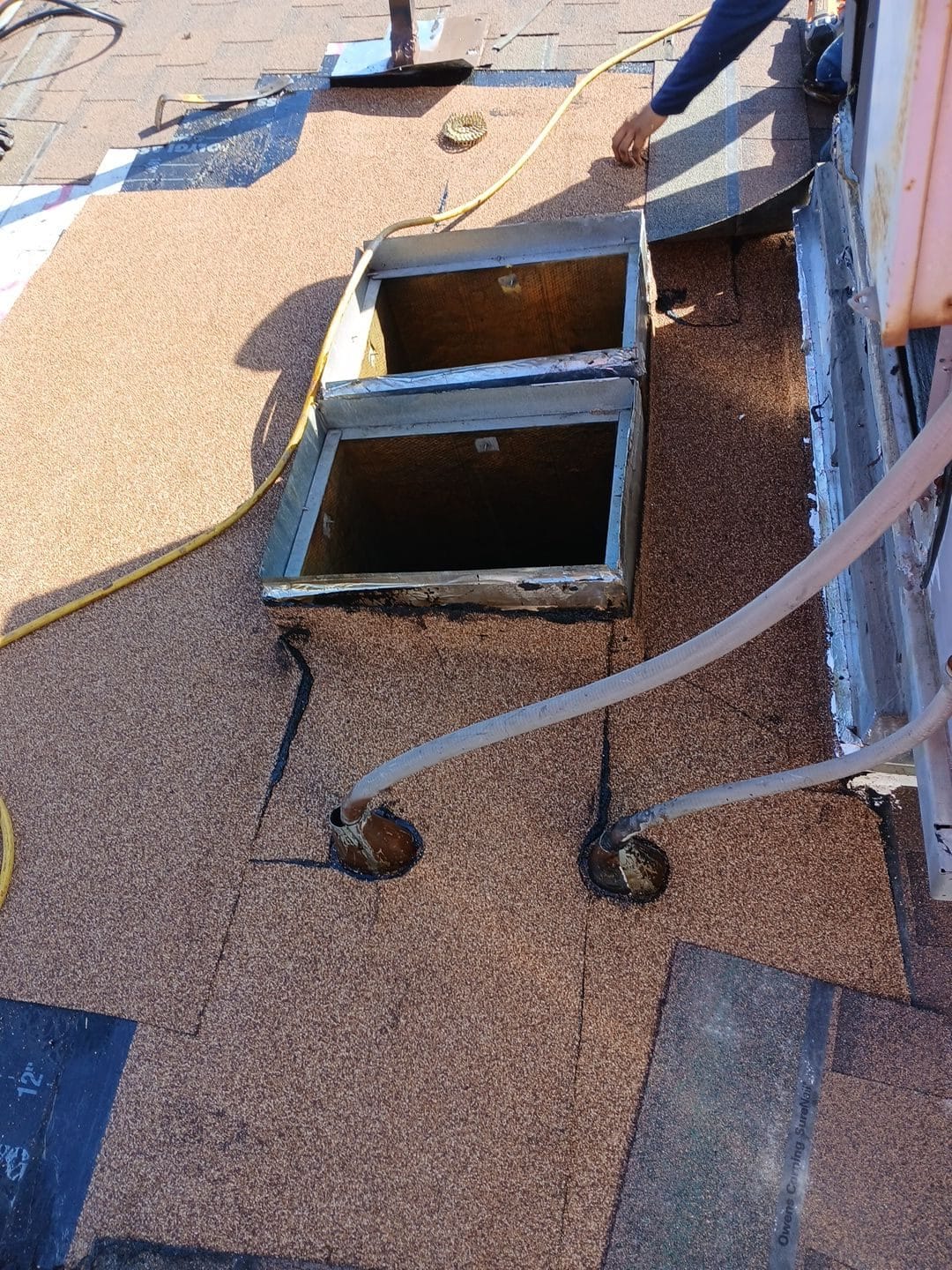 Skylight curb opening in new asphalt shingle roof with hoses | Roof Replacement Inc Skylight curb opening in new asphalt shingle roof with hoses — Roof Replacement Inc