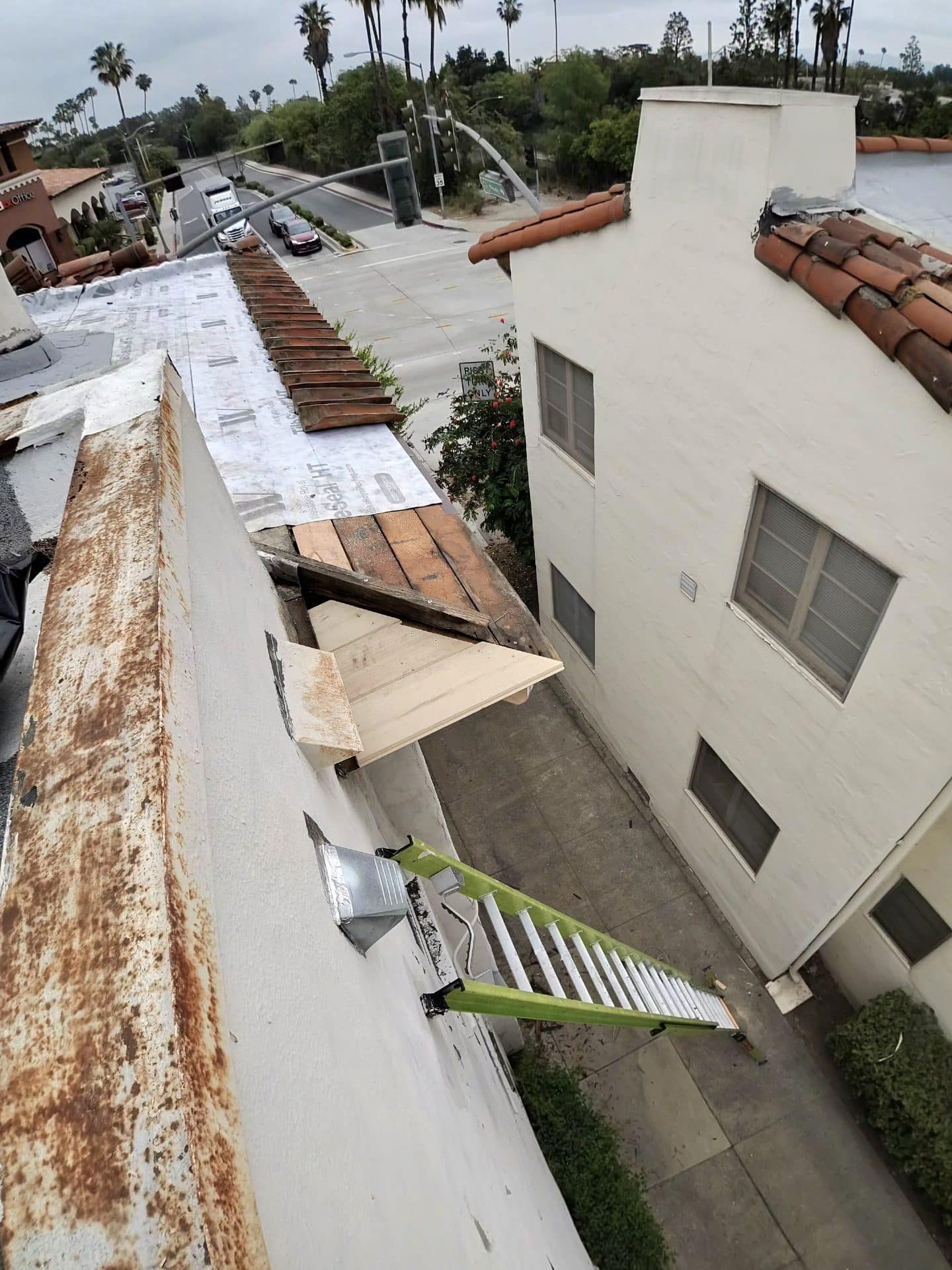 Tile roof eave repair, exposed decking, underlayment, ladder, metal flashing — Roof Replacement Inc