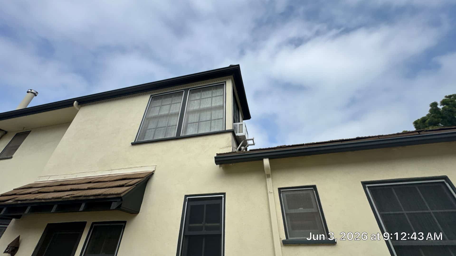Two-story stucco exterior, tile roof sections, gutters, large upper window | Roof Replacement Inc Two-story stucco exterior, tile roof sections, gutters, large upper window — Roof Replacement Inc