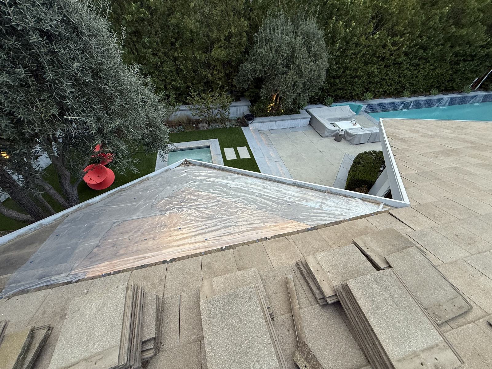 tile roof tear-off exposing underlayment over pool backyard — Roof Replacement Inc