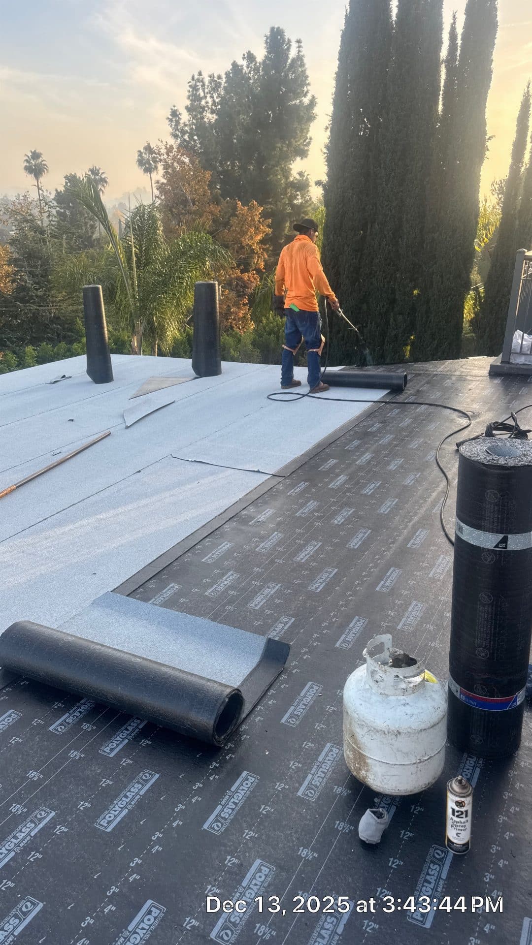 roofer applying torch-down modified bitumen membrane on flat roof — Glendale — Roof Replacement Inc