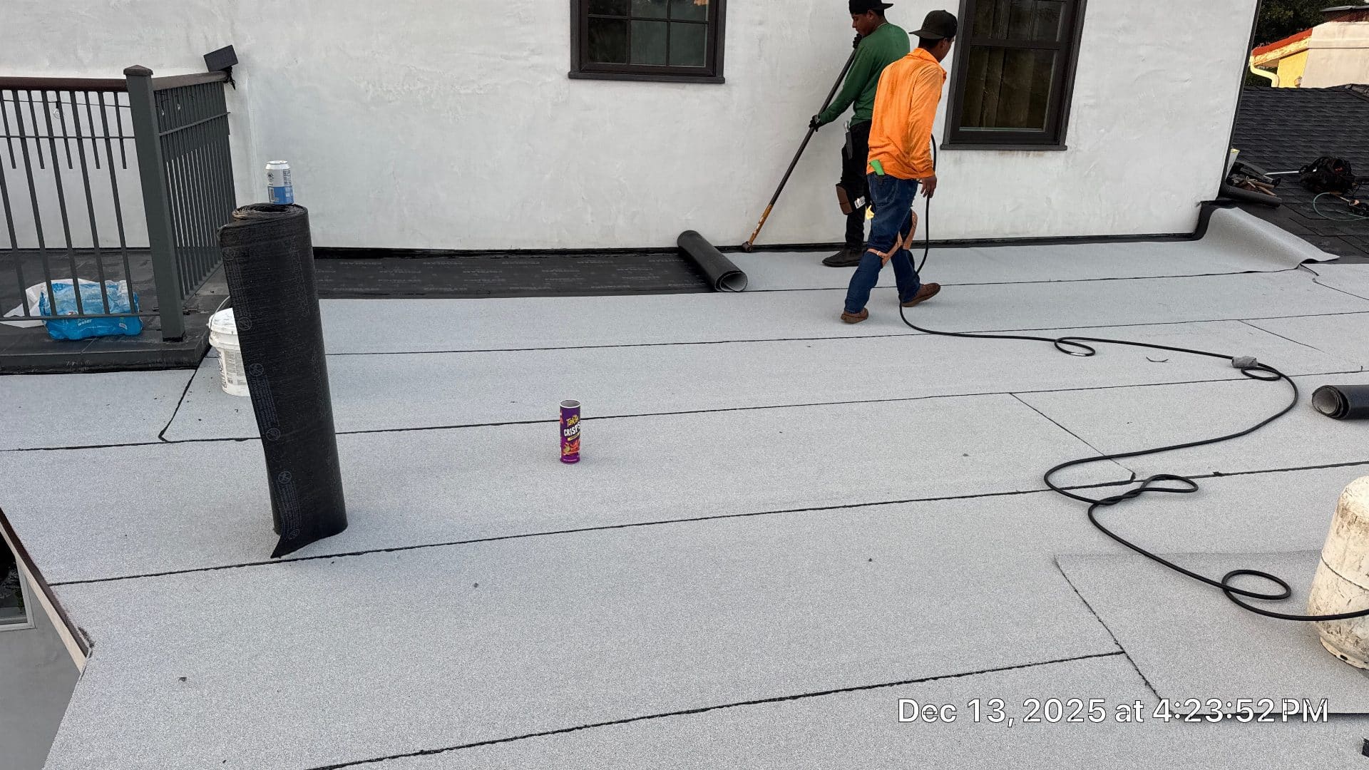 Two roofers torch-applying modified bitumen membrane on flat roof — Glendale — Roof Replacement Inc