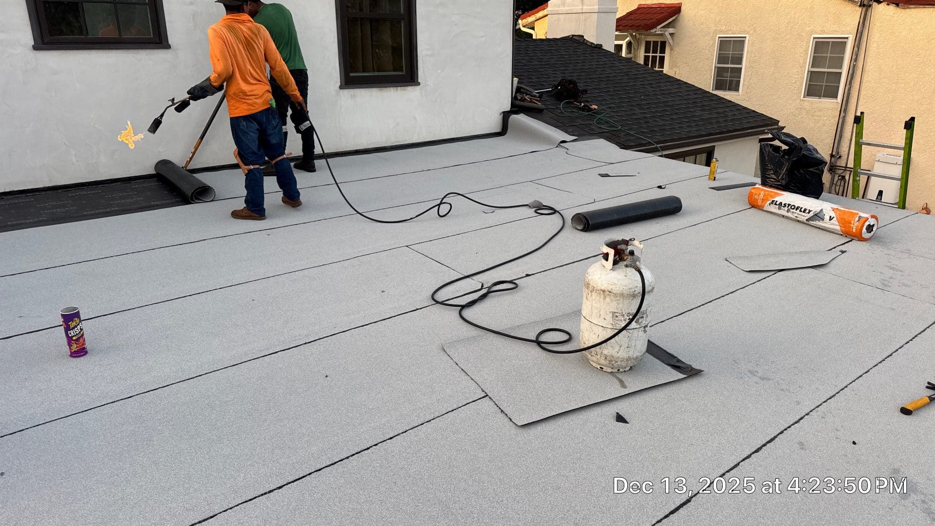 Roofers torch-applying modified bitumen cap sheet on flat roof in Glendale | Roof Replacement Inc roofers torch-applying modified bitumen cap sheet on flat roof — Glendale — Roof Replacement Inc