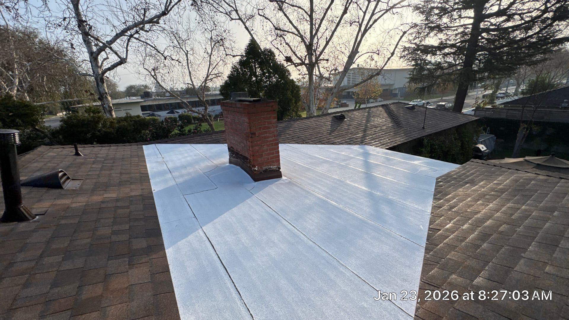 White TPO flat roof membrane installed around brick chimney in Burbank | Roof Replacement Inc white TPO flat roof membrane installed around brick chimney — Burbank — Roof Replacement Inc