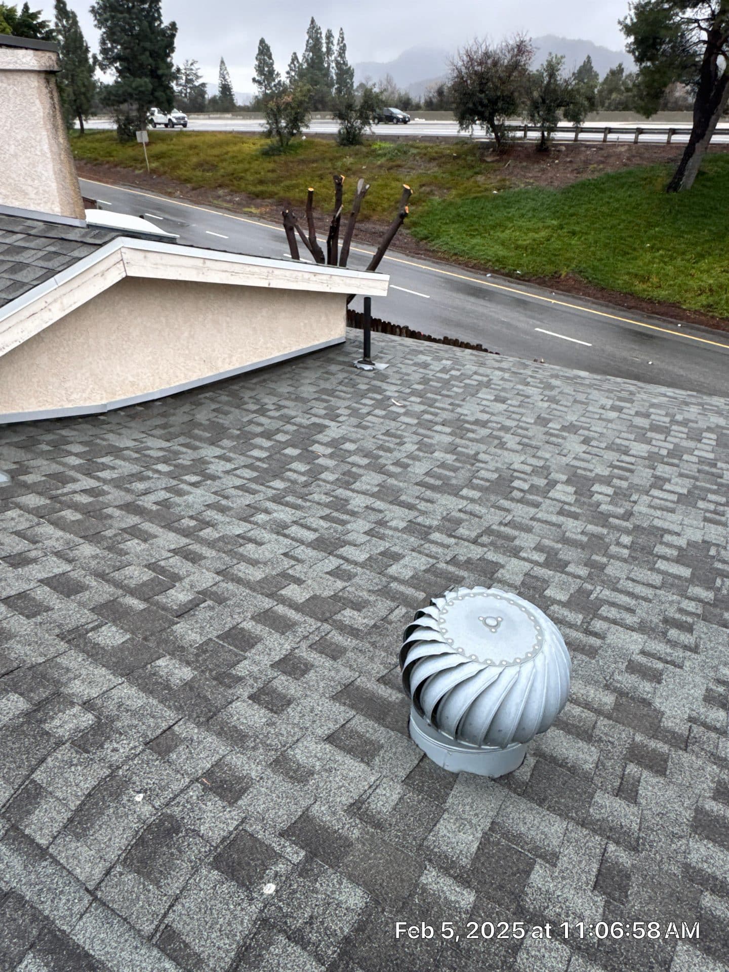 Turbine vent on gray asphalt shingle roof, road visible in La Crescenta-Montrose | Roof Replacement Inc turbine vent on gray asphalt shingle roof, road visible — La Crescenta-Montrose — Roof Replacement Inc