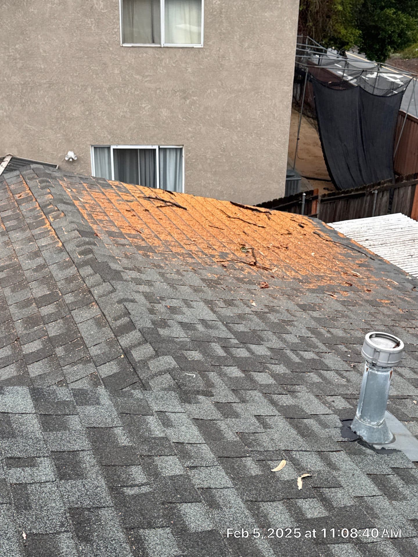 Asphalt shingles blown off exposing orange OSB wood decking in La Crescenta-Montrose | Roof Replacement Inc Asphalt shingles blown off exposing orange OSB wood decking — La Crescenta-Montrose — Roof Replacement Inc