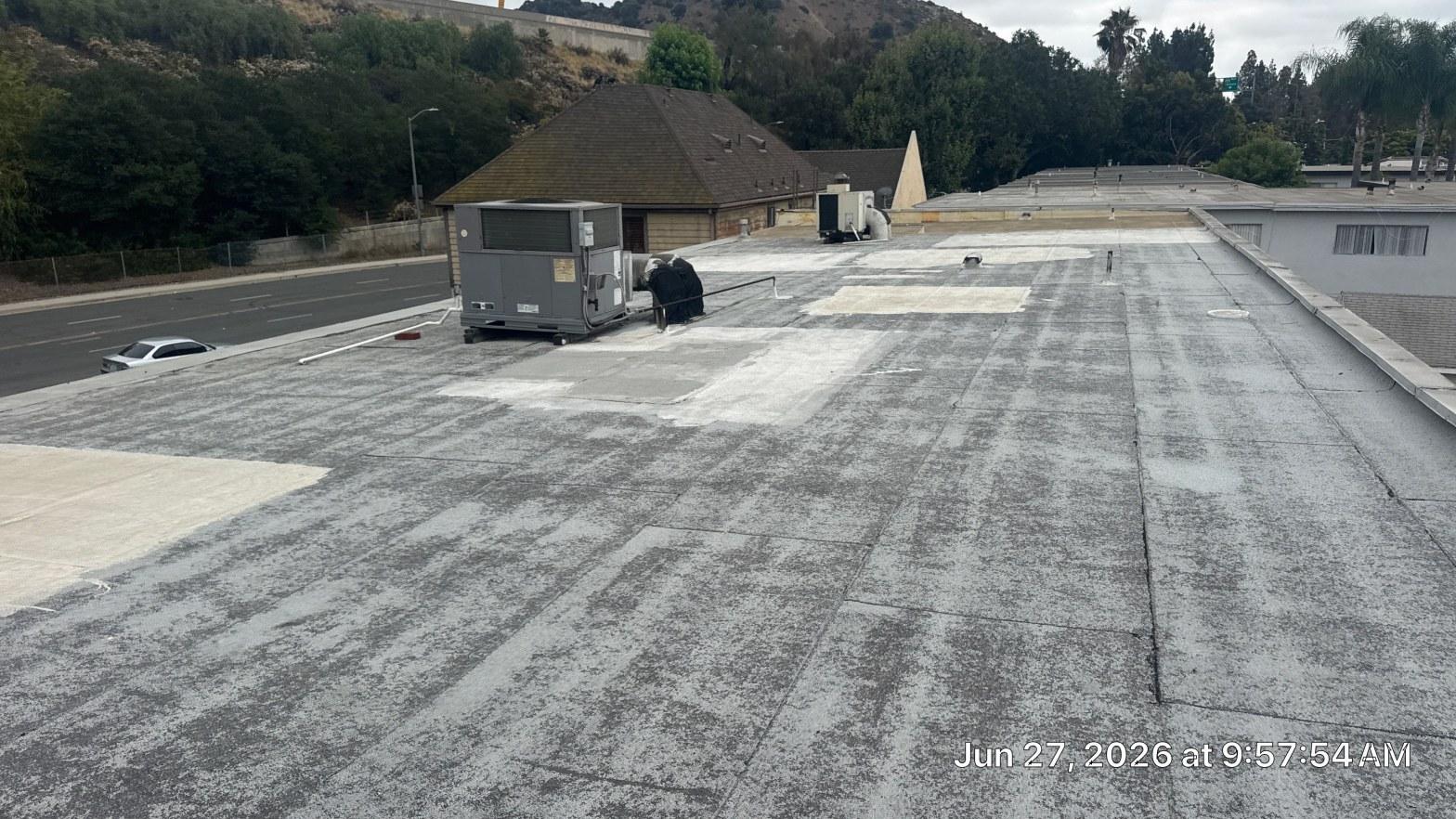Newly installed white TPO cool roof membrane on a flat California home rooftop in bright sunlight