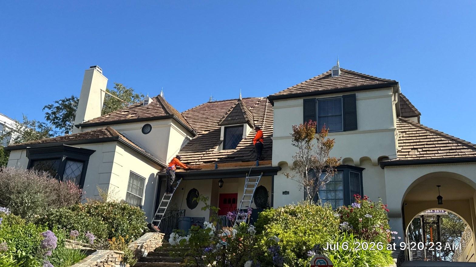 Tile roof replacement in progress on a Southern California home showing new clay tiles and underlayment