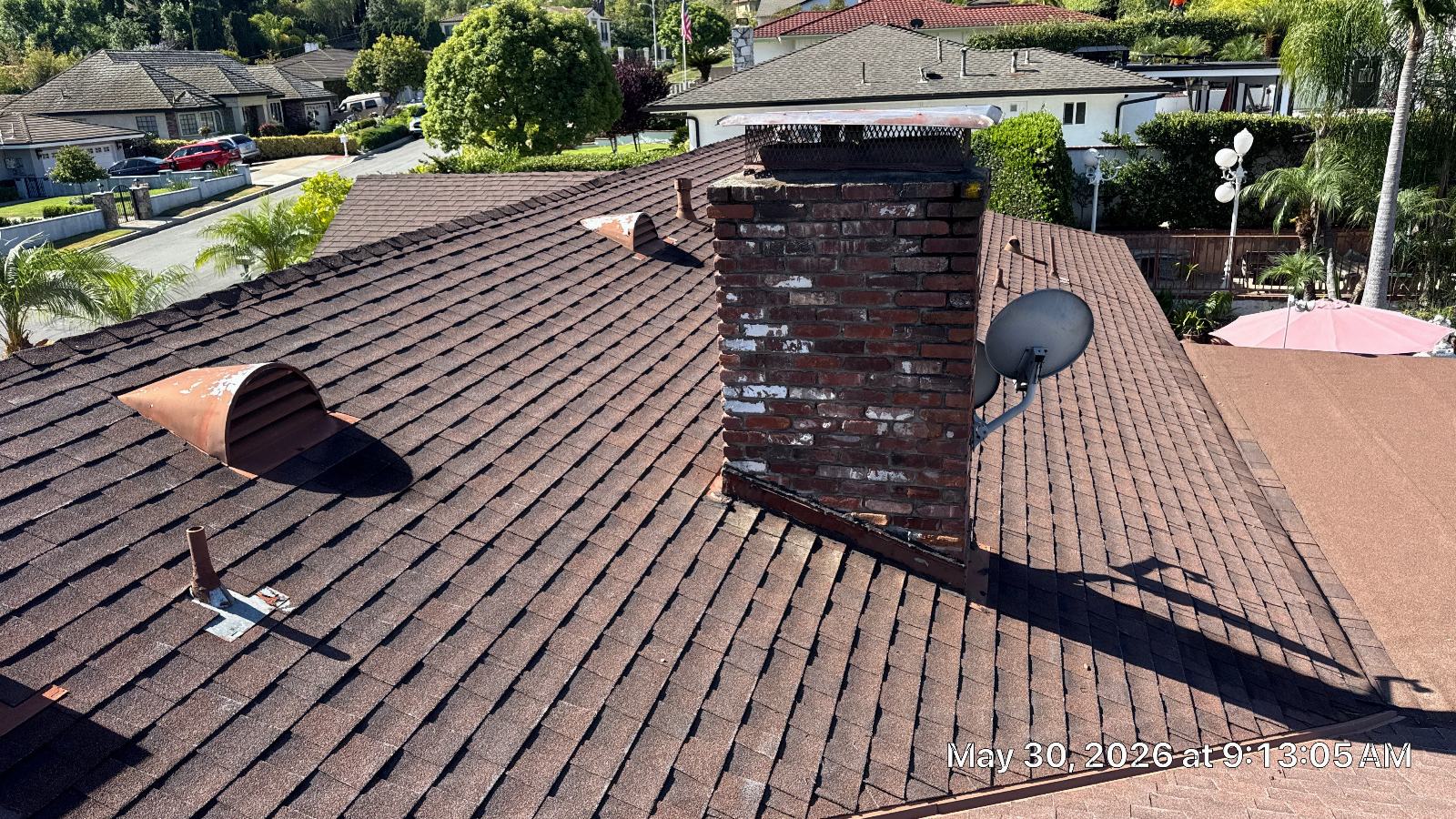 Brown asphalt shingle roof with brick chimney, satellite dish, and vents — San Gabriel Valley — Roof Replacement Inc